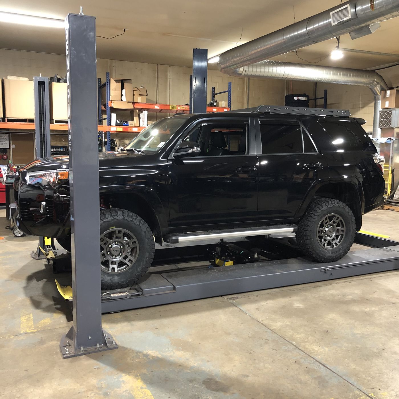 Lifted black Toyota 4Runner on a shop lift