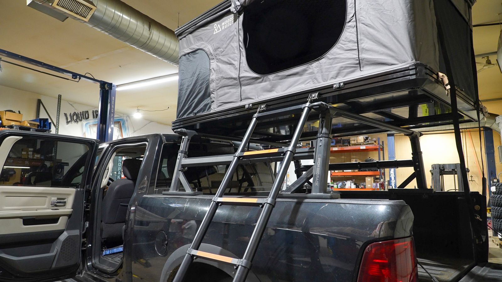 Pickup truck with an overland bed rack and rooftop tent in the shop