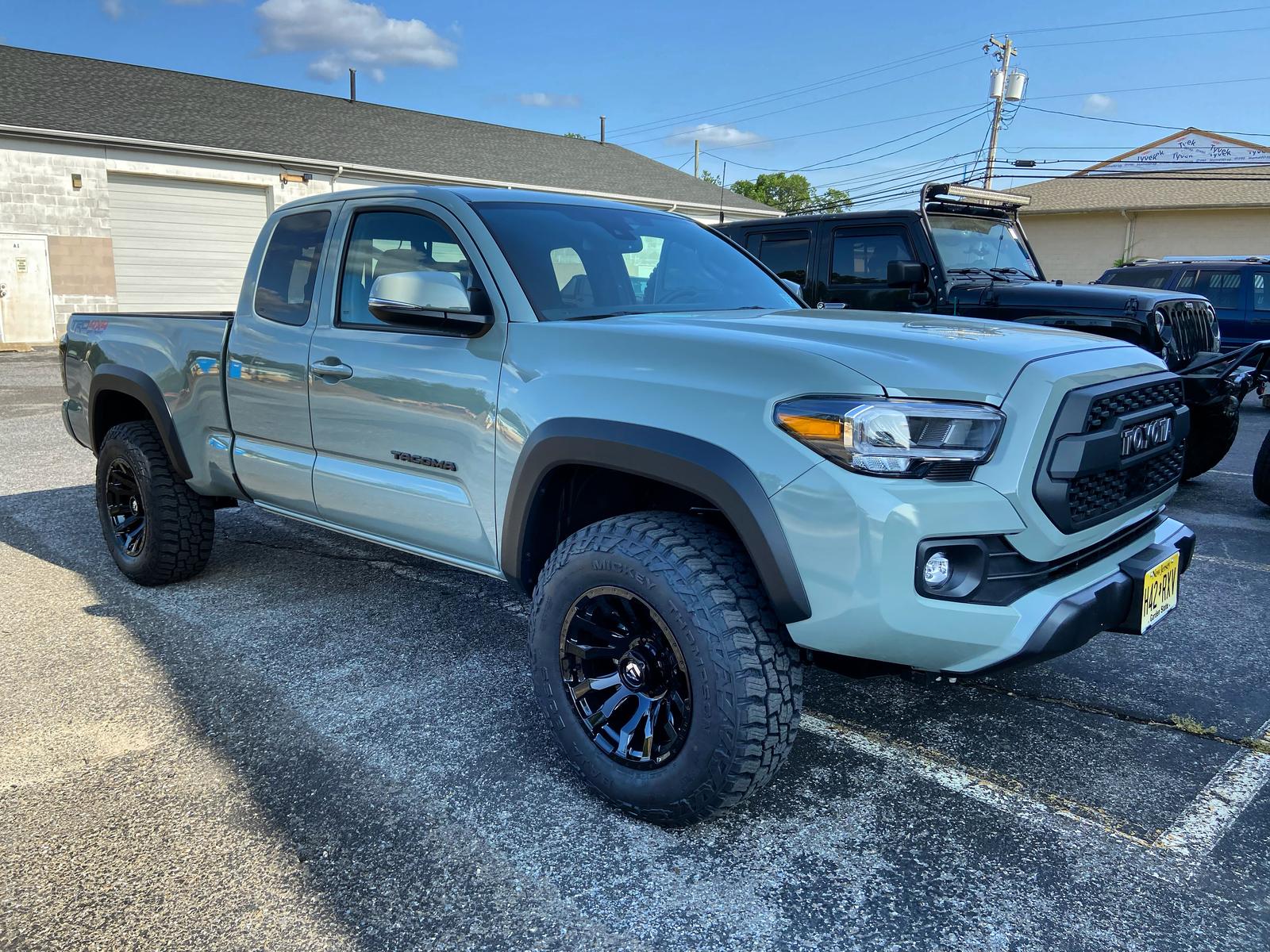 Lifted Toyota Tacoma TRD on black wheels and all-terrain tires